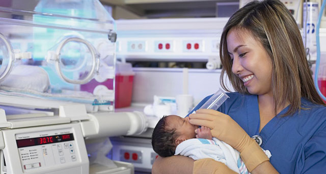 a nurse feeding a preemie baby with a tiny bottle