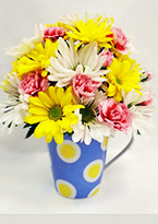 a cute blue polka-dot mug with a cheerful arrangement of yellow and white flowers inside