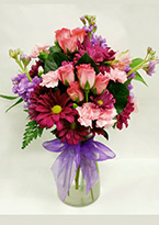 a tall, elegant flower arrangement with feminine pinks, purples and reds