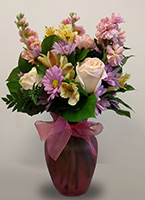 a simple flower arrangement in a light pink transparent vase