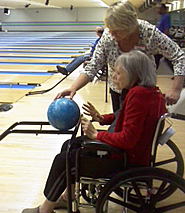 resident and staff person bowling