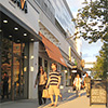 people walking on a sidewalk in a shopping center